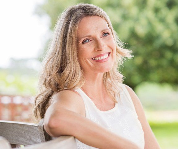 Woman smiling after dental implant tooth replacement