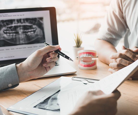 Dentist and patient reviewing dental insurance forms